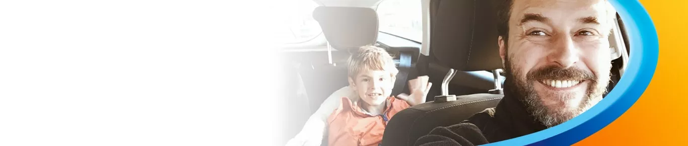 Man driving son in car, smiling
